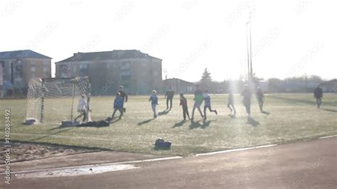 Little Boys playing soccer on the sports field next to goal. boy is ...