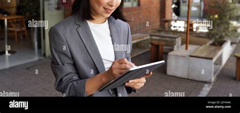 Happy Professional Woman Taking Notes Using Digital Tablet Standing