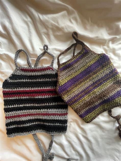 Two Crocheted Purses Laying On Top Of A White Bed Next To Each Other