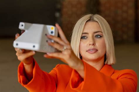 A Lovely Blonde Model Poses Outdoors Using Her Camera While Enjoying The Spring Weather Stock