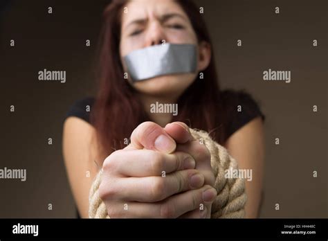 Brunette Hostage Gagged And Tied Hands On Blank Background Stock Photo