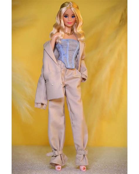 A Barbie Doll Dressed In Beige Clothes And Shoes With Her Hair Pulled