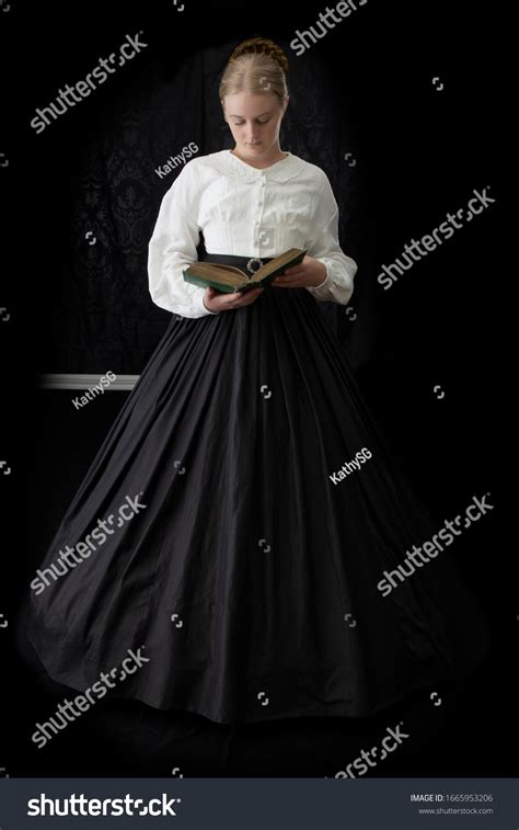 Victorian Woman Reading Book Against Dark Stock Photo