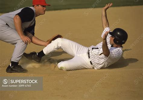 Baseball Player Sliding Into A Base Superstock