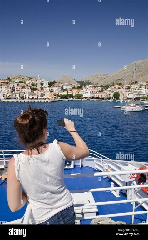 Woman Taking A Photograph From The Deck Of A Greek Island Ferry As It