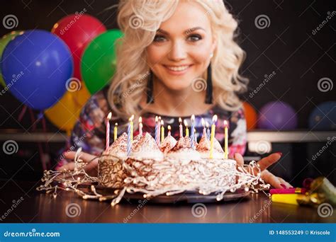 Birthday A Young Woman Blows Out The Candles On Her Birthday Cake