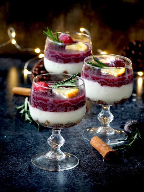 Three Glasses Filled With Dessert And Garnished With Rosemary Sprigs On Top