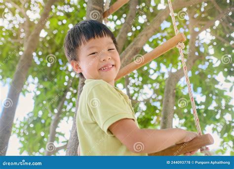 Mignonne Asiatique Jardin D Enfants Garçon S Amuser Face Défi Essayer De Grimper Sur L Arbre