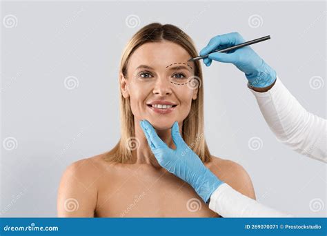 Plastic Surgeon Drawing Contours Around Female Eye Before Surgery Stock