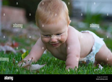 Baby Crawling In Grass Stock Photo Alamy