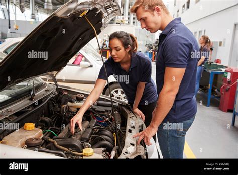 Two Apprentice Mechanics Looking At The Engine In A Car Stock Photo Alamy