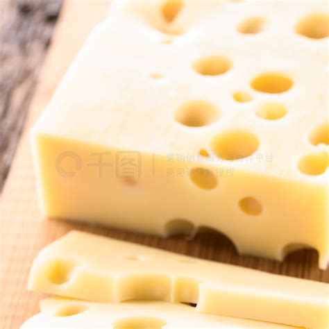 emmental高清图片 木制切菜板上的 EmmentalEmmentaler 或 Emmenthal 奶酪的片断和切片选择性聚焦将三