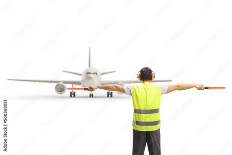 Back View Of An Marshaller Signalling With Wands In Front Of An