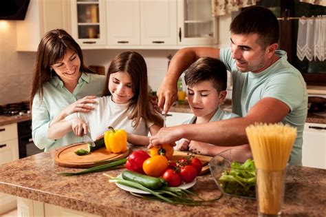 Familia Preparando Comida Juntos En La Cocina Foto Gratis