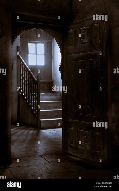 Wooden Door Leading To A Dark Room With Window Revealing High Levels Of