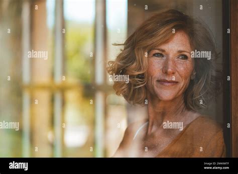 Thoughtful Mature Woman Seen Through Glass Window Stock Photo Alamy