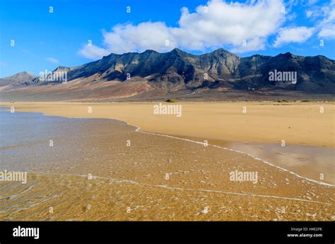 Reflection Of Mountains In Wet Sand On Cofete Beach In Secluded Part Of