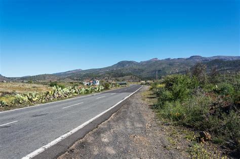 Premium Photo Asphalt Road Leading To The Mountains On A Sunny Day