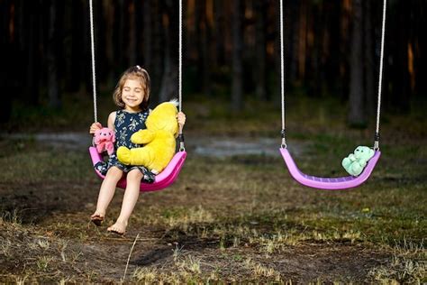 Premium Photo Cute Girl Sitting On Swing At Park