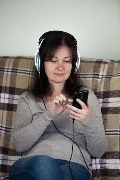 Premium Photo Mature Woman Listening Music On Headphones While