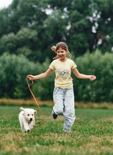 On The Ground Cute Little Girl Is With Golden Retriever Dog On The