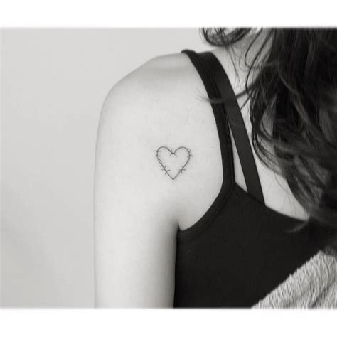 Fine line barbed wire heart tattoo located on the