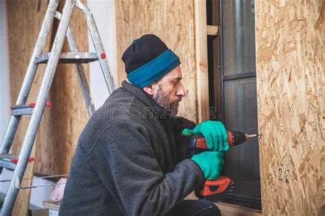 El Hombre Con La Barba Tuerce El Tornillo Con La Herramienta Imagen De