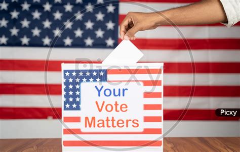 Image Of Close Up Of Hands Placing Vote Inside The Ballot Box With Your