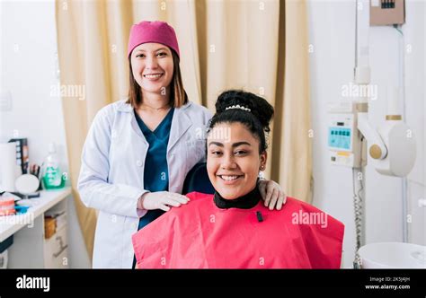 Female Dentist With Satisfied Patient Smiling At Camera Female Dentist With Patient Smiling