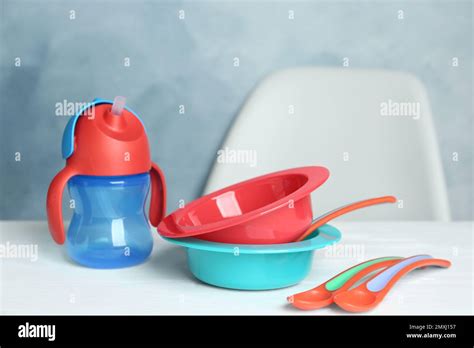 Set Of Plastic Dishware On White Table Serving Baby Food Stock Photo