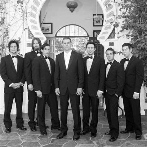 A Group Of Men In Tuxedos Standing Next To Each Other