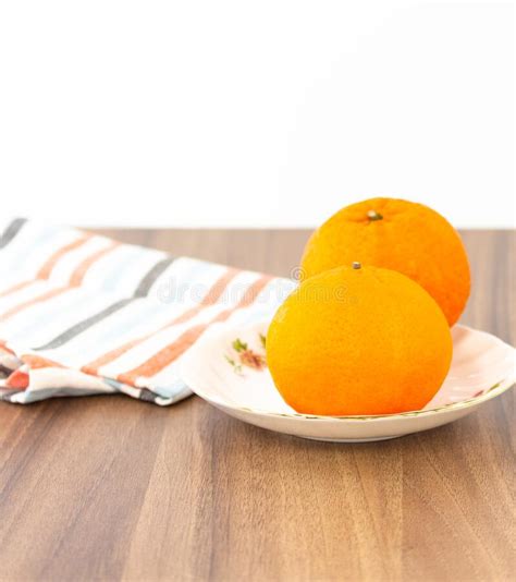 Orange On Plate Besides With Napkin On Dark Brown Wood Table Stock