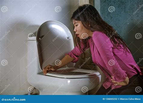 Young Drunk Or Pregnant Asian Woman Vomiting And Throwing Up In Toilet