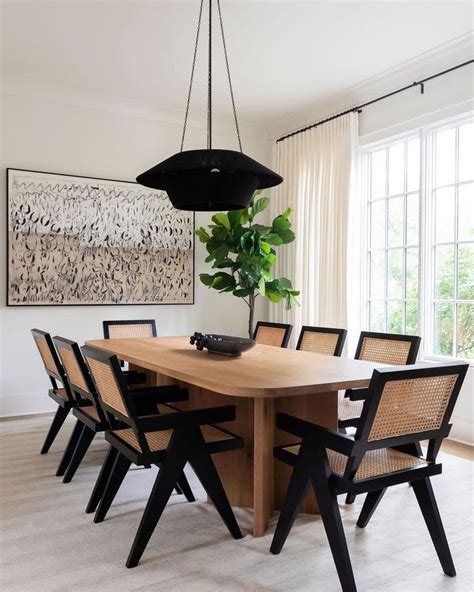 A Dining Room Table With Six Chairs And A Plant In The Center Next To