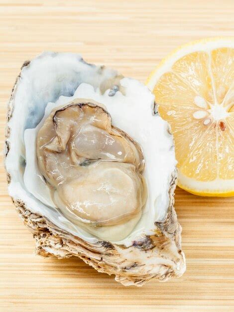 Premium Photo Close Up Of Oyster And Lemon Slice On Table