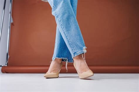 Premium Photo Closeup Of Female Legs In Blue Jeans And Fancy Beige