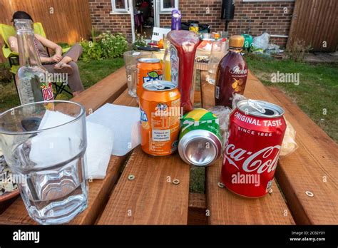 Empty Drinks Cans And Bottles On A Garden Table In The Summer Stock