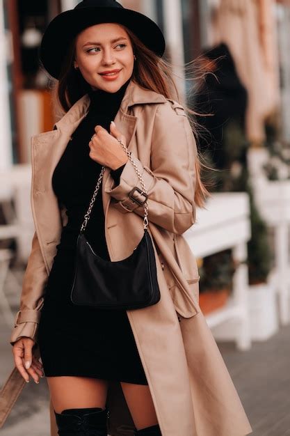 Mujer Joven Con Estilo En Un Abrigo Beige Y Un Sombrero Negro Foto