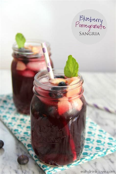 Two Mason Jars Filled With Blueberries Peaches And Mint On Top Of A Table