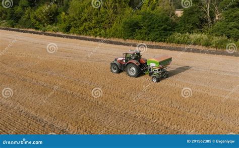 Farmer On Tractor Fertilizing Agricultural Field Spreading Mineral