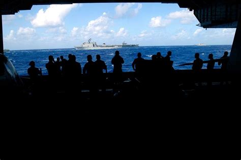 USS Kitty Hawk (CV 63) Sailors line up in the hangar bay to watch the ...