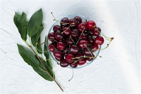 Dos Cerezas Rojas Con Las Hojas Verdes Aisladas En Un Fondo Concreto