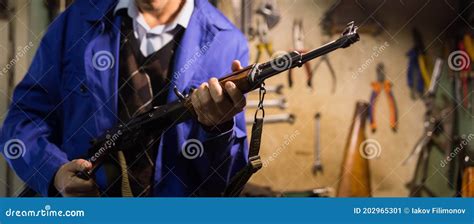 Kalashnikov Assault Rifle In Hands Of Gunsmith In Weapons Workshop