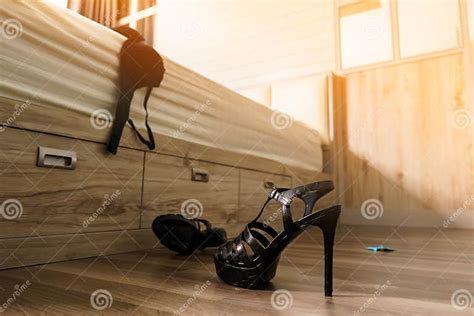 Black Panties Bra Condom And High Heels Shoes On The Floor Near Bed Sex Concept Stock Image