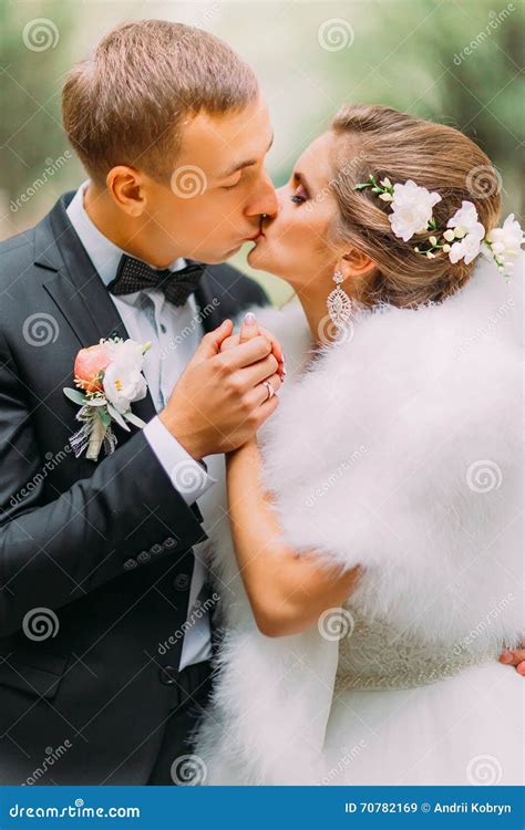 Handsome Groom Sensual Kisses His Attractive Happy Bride Outdoors