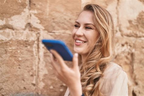 Jeune Femme Blonde Souriante Confiante Parlant Sur Le Smartphone Au Parc Photo Gratuite