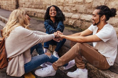 Group Of Friends Sitting Together Stacking Their Hands On One An Stock