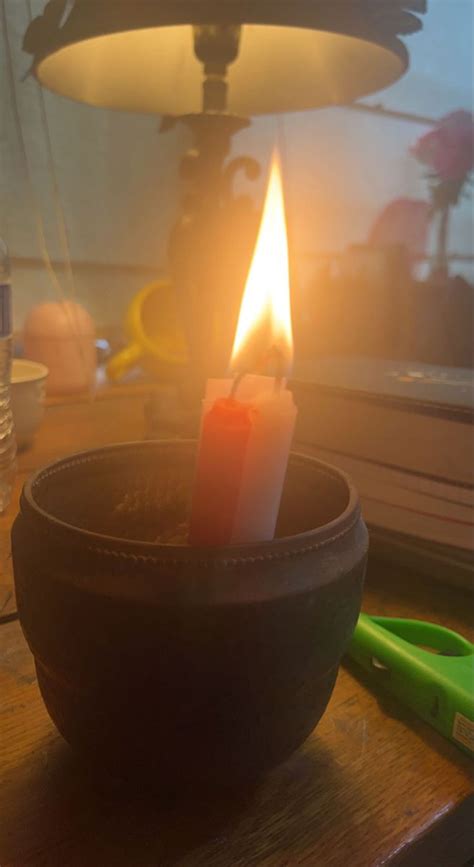 A Lit Candle Sitting In A Bowl On A Table