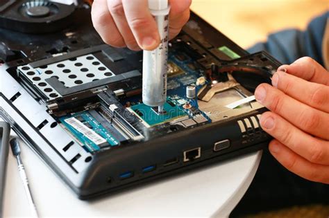 Hand A Repairman Uses Thermal Paste Syringe Apply Thermal Compound To A