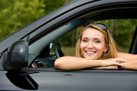 Retrato de uma bela jovem alegre no carro novo ao ar livre Foto Grátis